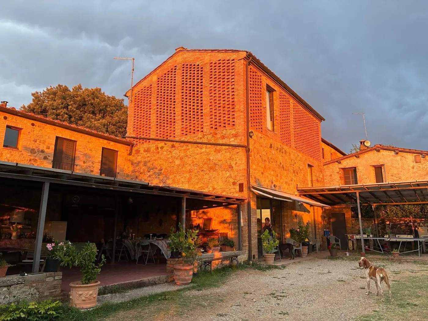 Il casale di Podere Noceto al tramonto, con il portico e il giardino