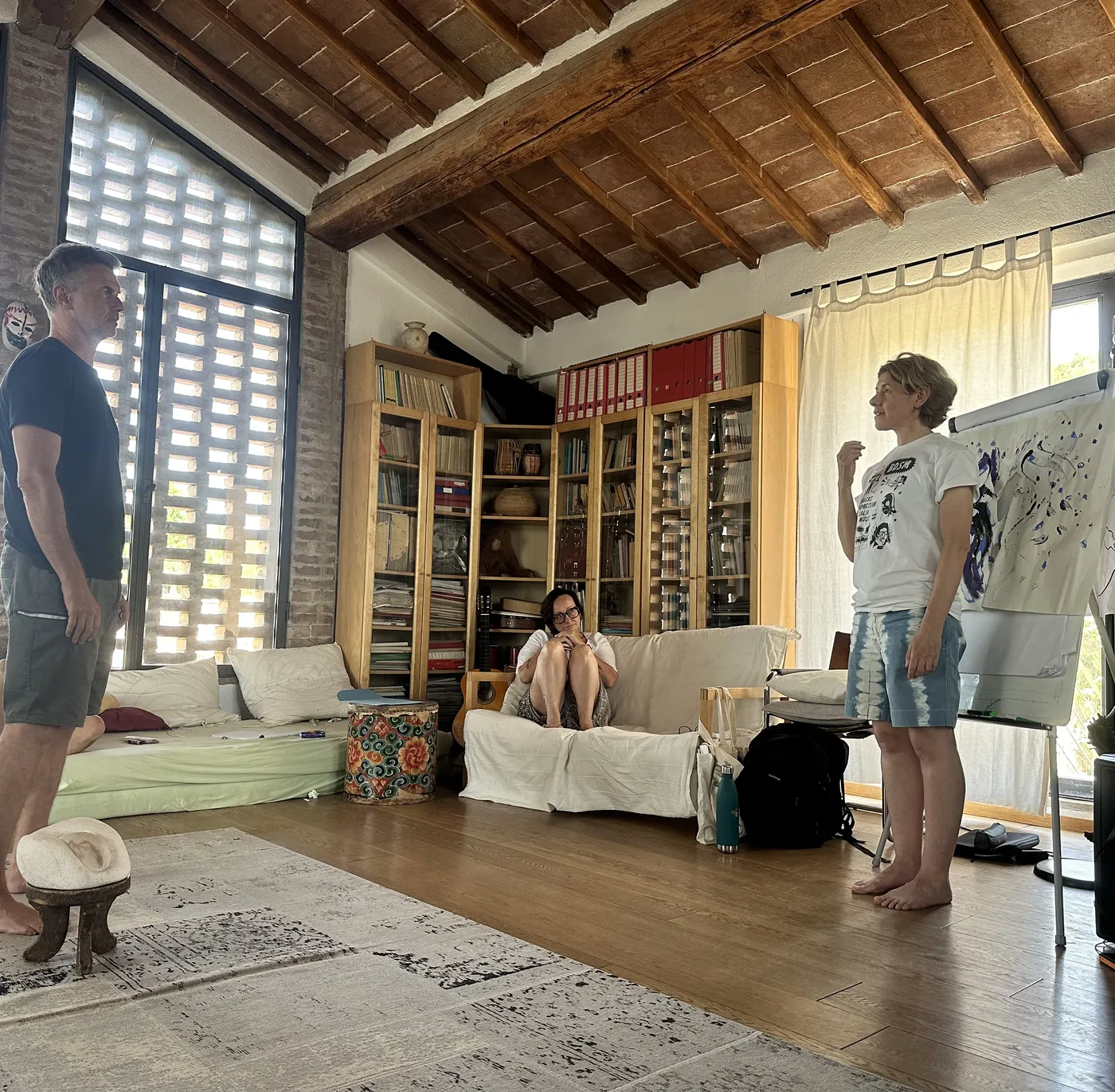 Tre persone nel salone durante un lavoro esperienziale, con una lavagna con un disegno